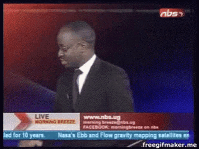 a man in a suit and tie is standing in front of a screen that says ' live morning breeze '