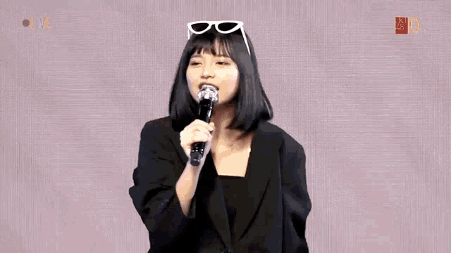 a girl singing into a microphone in front of a cartoon pig