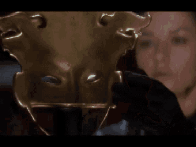 a woman in a black glove holds a gold mask