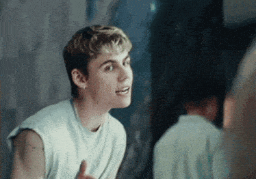 a young man giving a thumbs up while looking at himself in the mirror