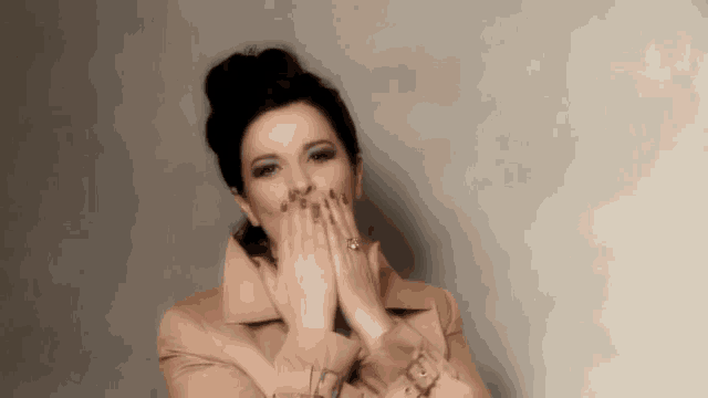 a woman with red nails is covering her mouth with her hands