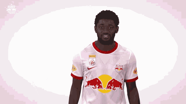 a man wearing a white jersey with a red bull on the front