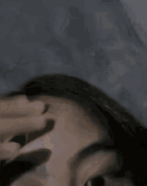 a close up of a woman 's face with her eyes closed and a blurred background .