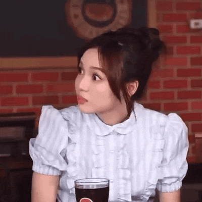 a woman is sitting at a table with a glass of pepsi .