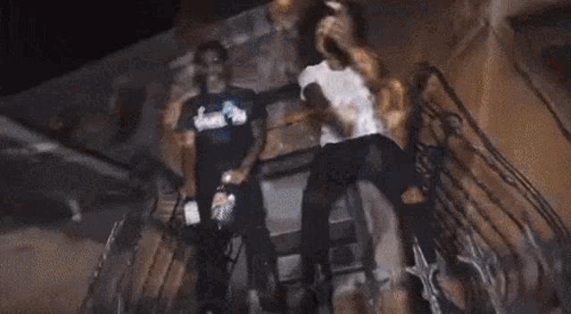 a group of people are dancing on a sidewalk at night .