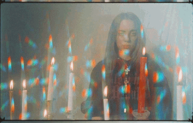 a woman is surrounded by candles and has a cross necklace on