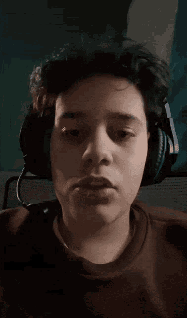 a young man wearing headphones with his eyes closed looks tired