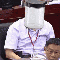 a man with a jar on his head is sitting in a chair