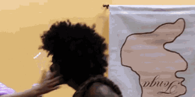 a woman 's hair is being touched by another woman in front of a banner that says tongo