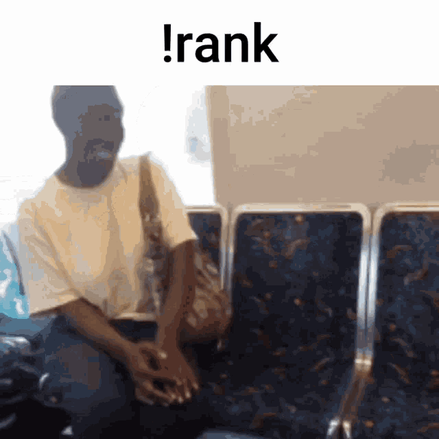 a man is sitting in a row of seats with the word rank written above him