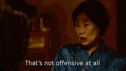 a woman in a blue dress is talking to another woman in a dark room .