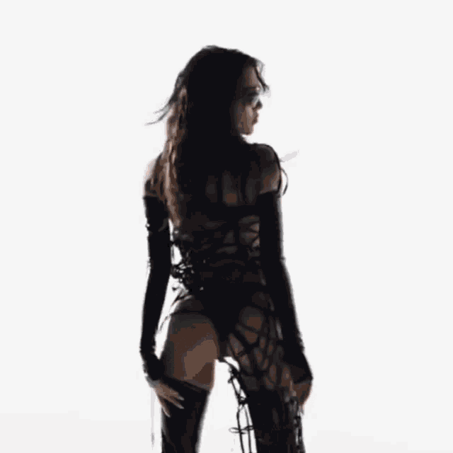 a woman in a black dress and sunglasses is laying on her back