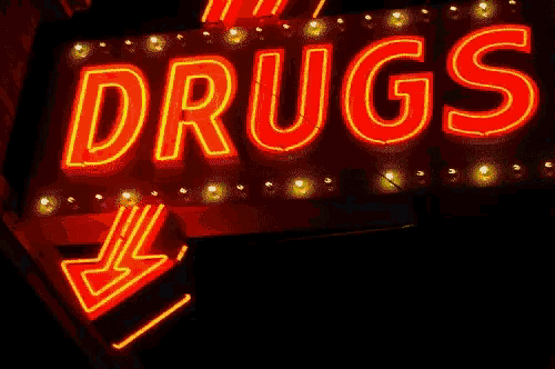 a neon sign that says " drugs " with an arrow pointing to the right