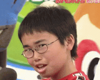 a young boy wearing glasses and a red shirt is making a funny face