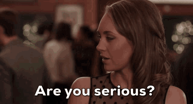 a woman says " are you serious " in a crowded room