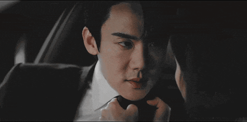 a man in a suit and tie is sitting in the back seat of a car with a woman .