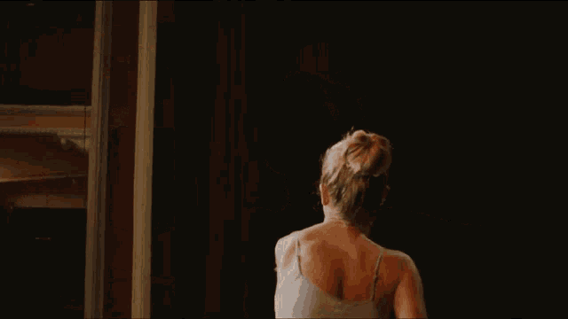a woman with her arms outstretched looking up