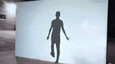a shadow of a man walking on a wall