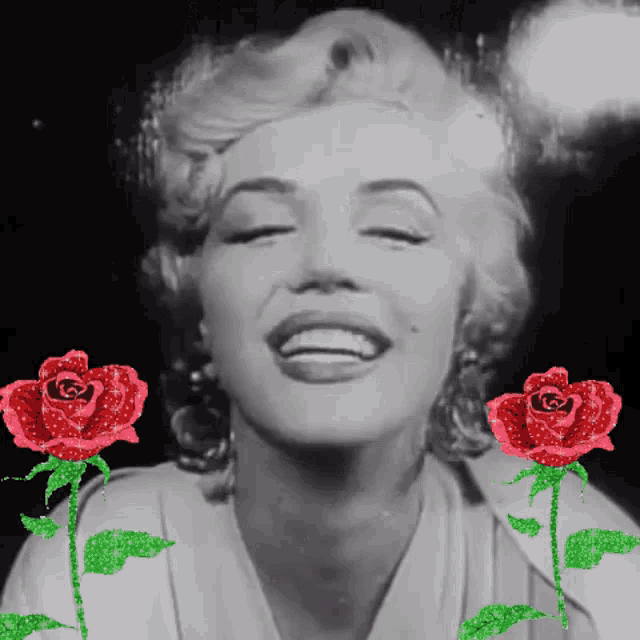 a black and white photo of a woman with red roses around her