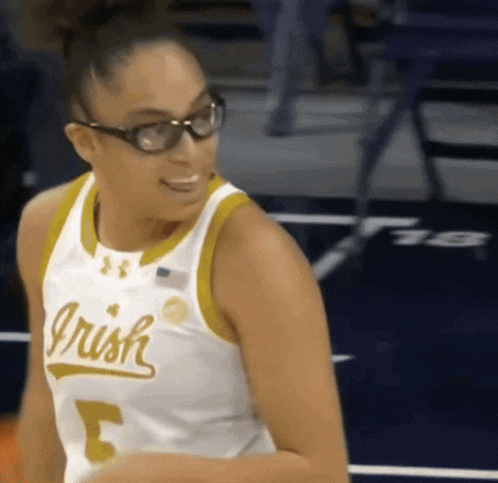a female basketball player wearing glasses and a jersey that says irish