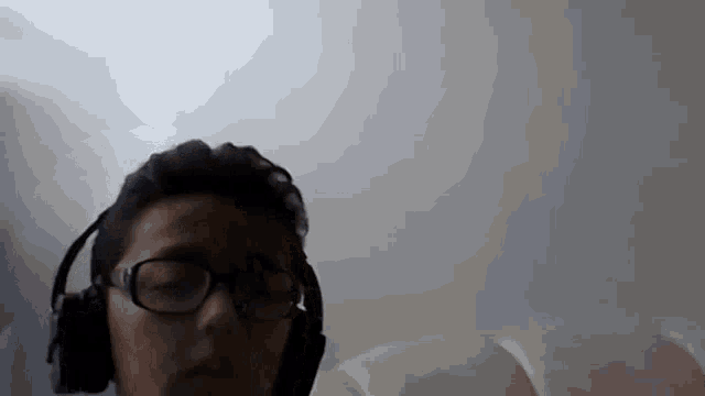a man wearing glasses and headphones looks at the camera