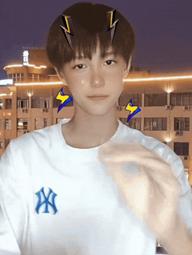 a young boy wearing a white shirt with the ny logo on it