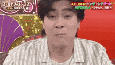 a man in a striped shirt is making a funny face in front of a sign that says " ゴールデン ストリッツ "