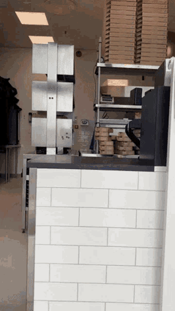 a stack of pizza boxes sit on a shelf in a restaurant