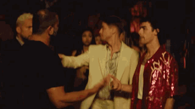 a group of people are dancing together in a dark room
