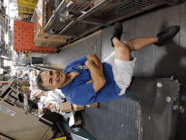 a man in a blue shirt is sitting on a suitcase