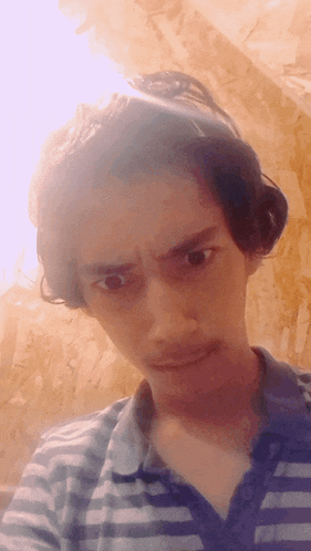 a man wearing a striped shirt is looking at the camera