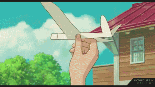 a hand is holding a paper airplane in front of a house with movieclips trailers written on the bottom