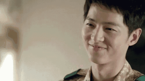 a close up of a man in a military uniform smiling and looking at the camera .