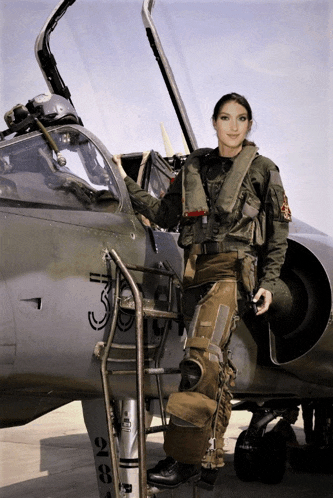 a woman in a military uniform is standing next to a plane with the number 3 on the side