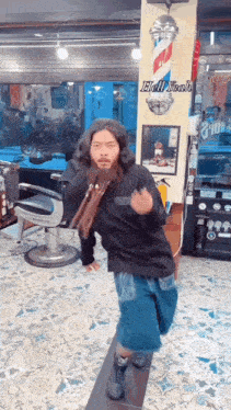 a man with a beard is dancing in a barber shop with the word hellyeah on the wall