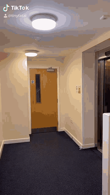 a hallway with a door and a sign that says ' no smoking ' on it