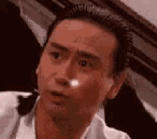 a close up of a man 's face with a white spot on his nose .