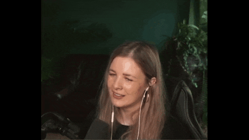 a woman is sitting in a chair wearing headphones and smiling .