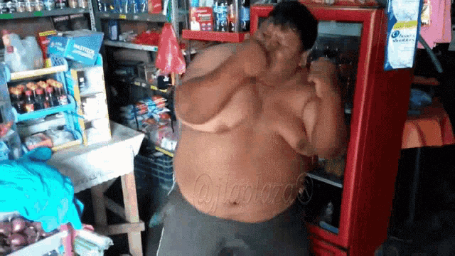 a man with a big belly is standing in front of a head and shoulders fridge