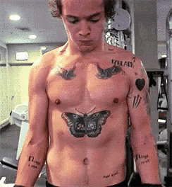 a shirtless man with a butterfly tattoo on his chest .