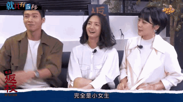 a man and two women are sitting in front of a sign that says ' 5 seconds '