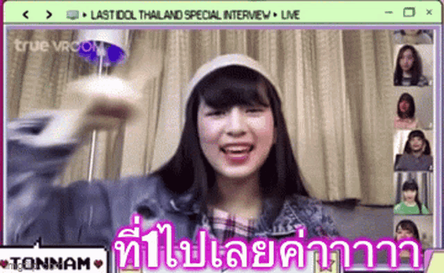 a girl in a hat is talking to a group of people on a video call .