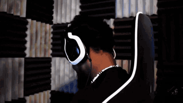 a man wearing headphones and sunglasses is sitting in a chair that says bose