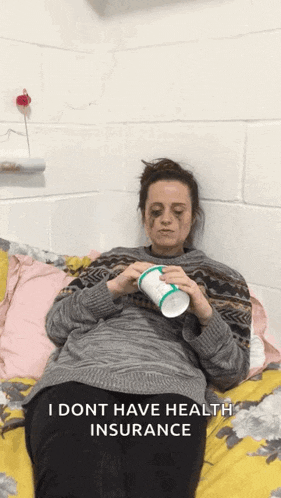 a woman is laying on a bed with a cup in her hand and the words i dont have health insurance