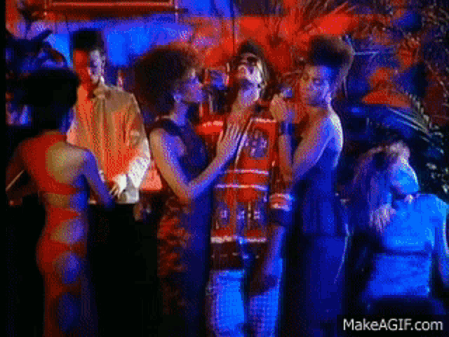 a group of people are dancing in a dark room with makeagif.com written on the bottom