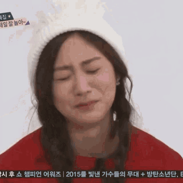 a woman wearing a white hat and a red jacket is making a sad face