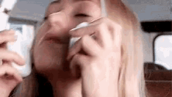 a woman is crying while holding a tissue to her face .