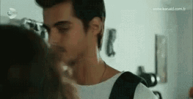 a man is kissing a woman on the forehead .