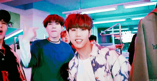 a group of young men are standing next to each other in a room and one of them has red hair .