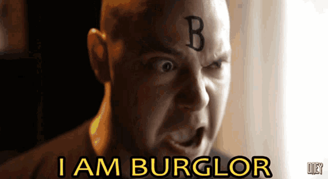 a man with a tattoo of the letter b on his forehead
